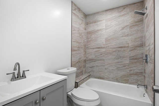 full bathroom featuring vanity, tiled shower / bath combo, and toilet