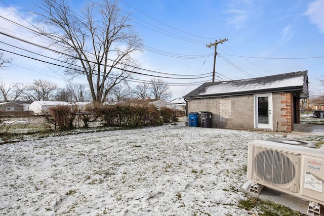 yard layered in snow featuring ac unit