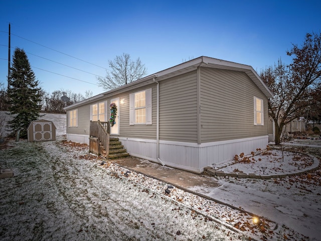 view of snow covered exterior with a storage shed