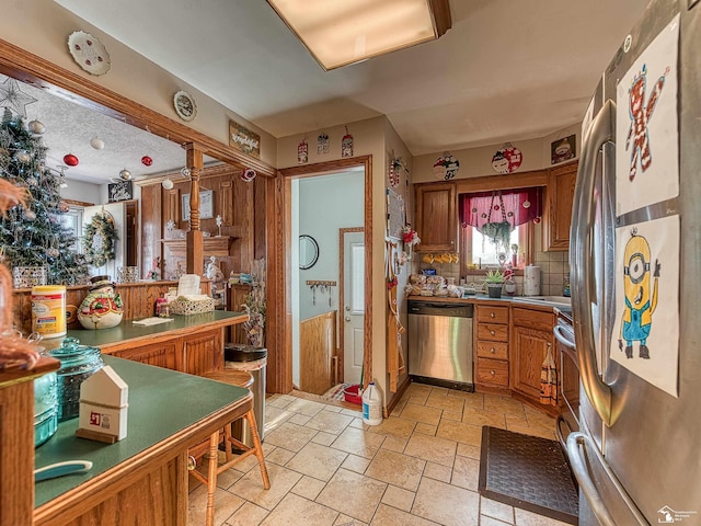 kitchen with kitchen peninsula, decorative backsplash, and appliances with stainless steel finishes