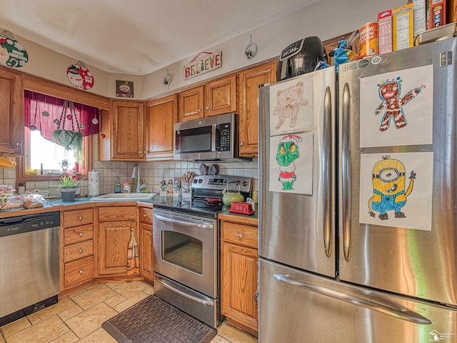 kitchen with backsplash, sink, and appliances with stainless steel finishes