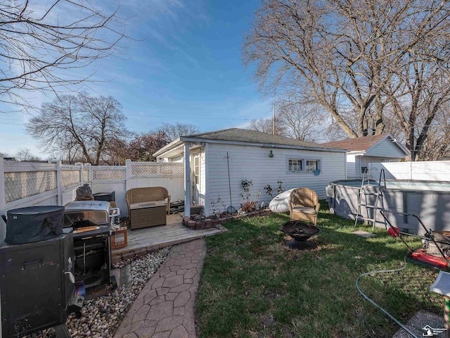 rear view of property featuring a pool side deck and a lawn