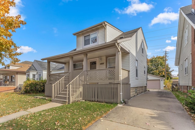 view of front of home featuring a front yard, covered porch, an outdoor structure, and a garage