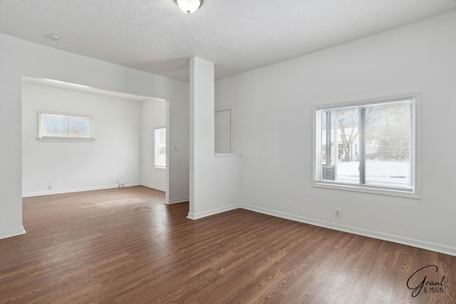 spare room featuring dark hardwood / wood-style flooring and a wealth of natural light