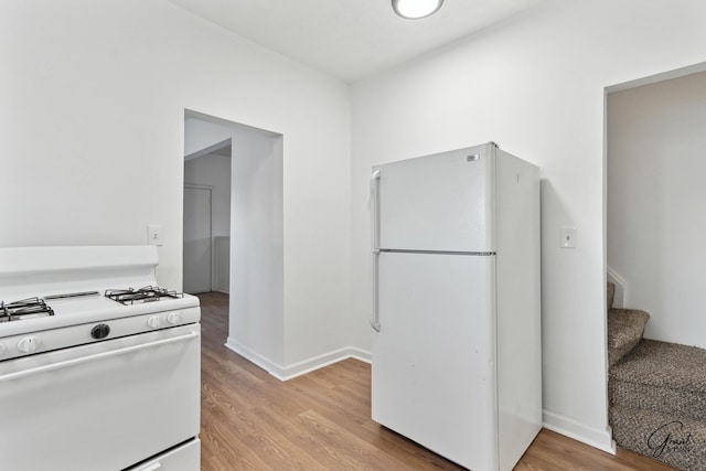 kitchen featuring light wood-type flooring and white appliances