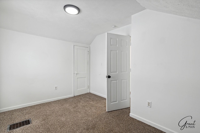 bonus room with carpet, a textured ceiling, and vaulted ceiling