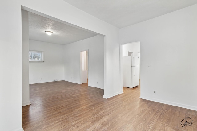 empty room featuring light hardwood / wood-style floors and a textured ceiling