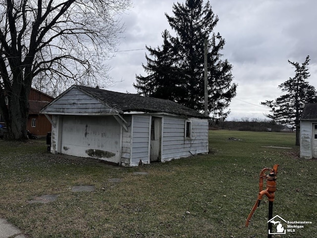 view of outbuilding featuring a garage and a lawn