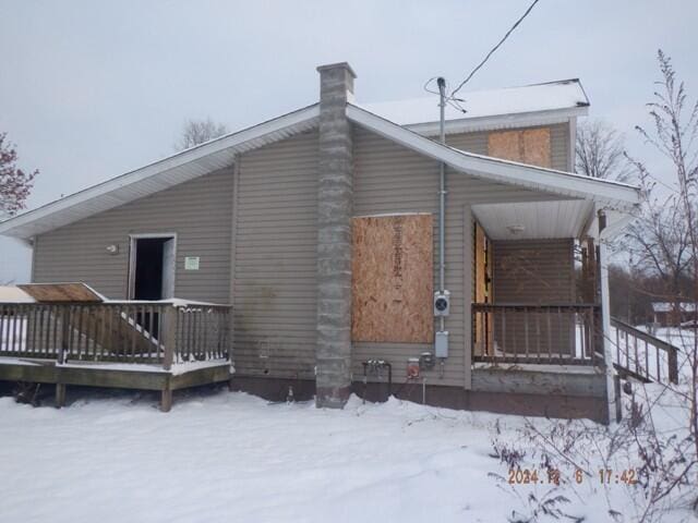 view of snow covered rear of property