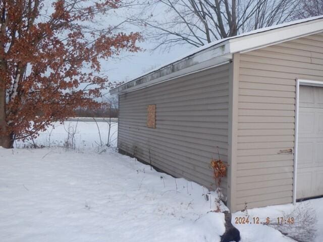 view of snow covered exterior featuring a garage