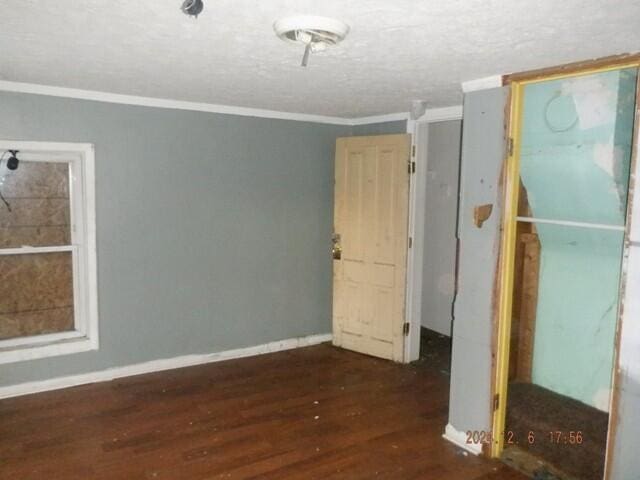 unfurnished bedroom featuring dark hardwood / wood-style flooring and ornamental molding