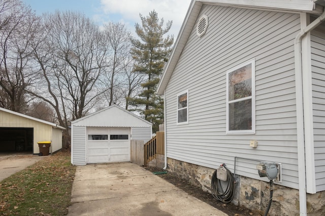 view of side of home with a garage and an outbuilding