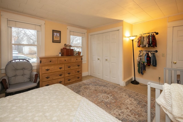 bedroom with a closet, carpet, and ornamental molding