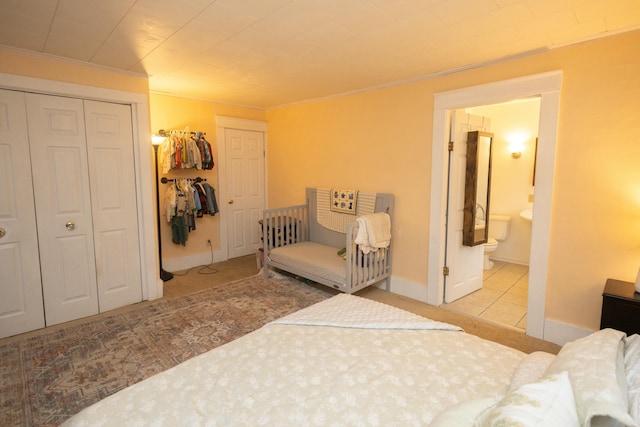 tiled bedroom featuring ensuite bath, a closet, and ornamental molding