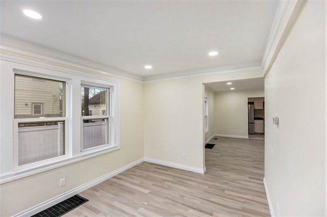 unfurnished room with light hardwood / wood-style flooring and ornamental molding