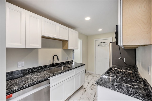 kitchen featuring dark stone countertops, white cabinetry, sink, and appliances with stainless steel finishes