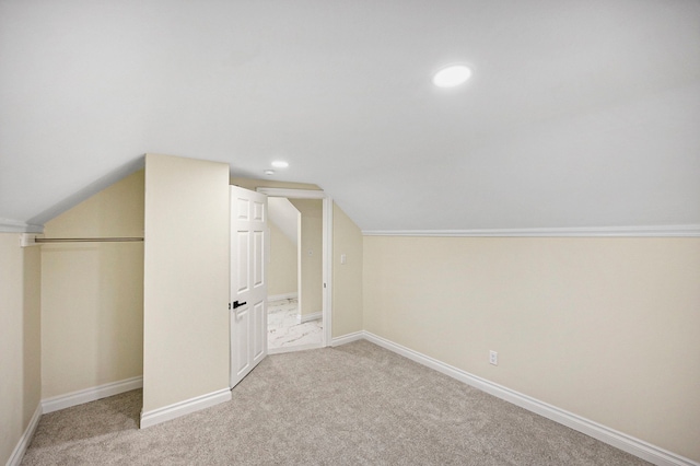 additional living space featuring light colored carpet and vaulted ceiling