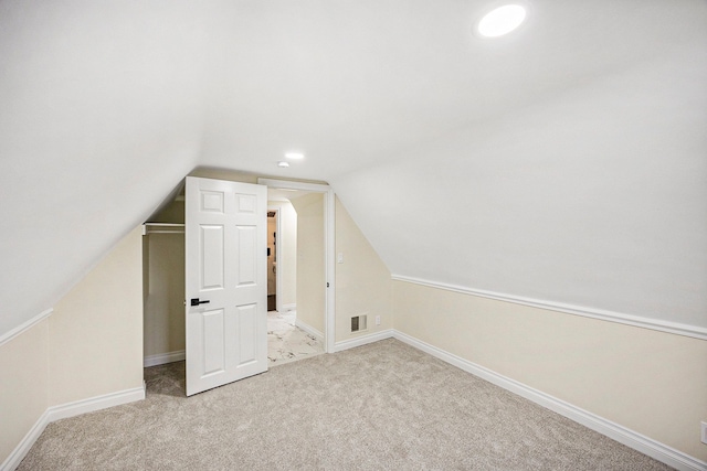 bonus room featuring light carpet and vaulted ceiling