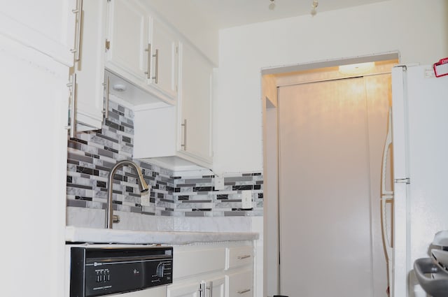 kitchen with decorative backsplash, white cabinets, and white refrigerator