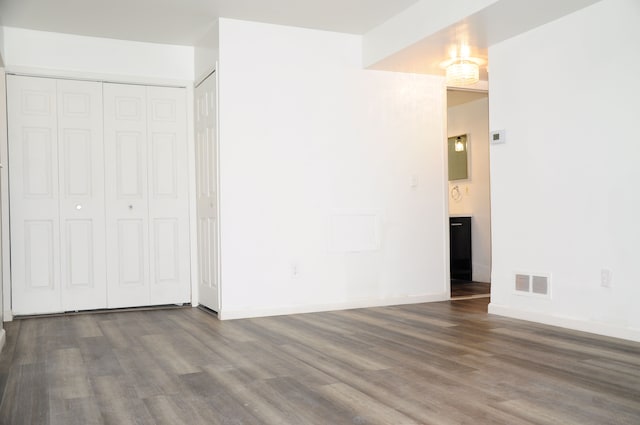 unfurnished bedroom featuring dark wood-type flooring and a closet