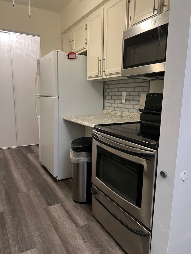 kitchen with white cabinetry, backsplash, dark hardwood / wood-style floors, and appliances with stainless steel finishes