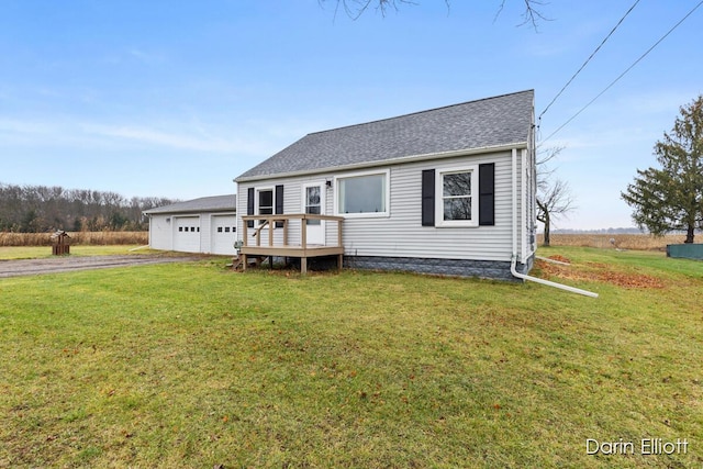 view of front facade with a garage, a deck, and a front lawn