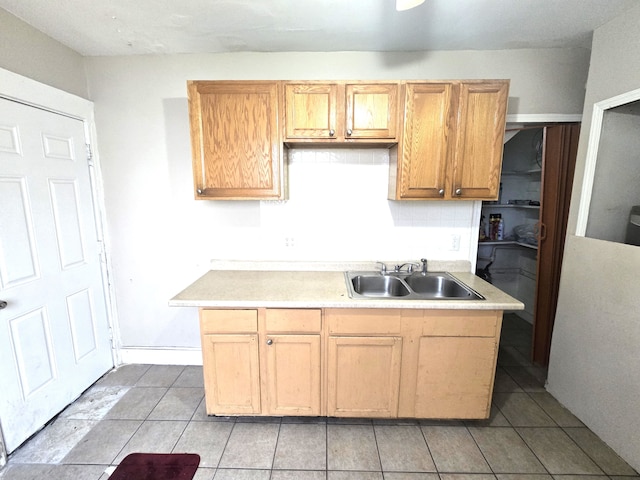 kitchen with tasteful backsplash, sink, light brown cabinets, and light tile patterned floors