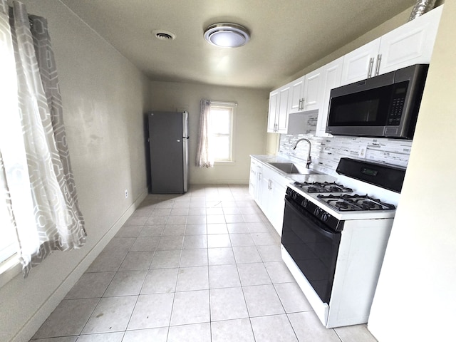 kitchen featuring sink, white cabinets, decorative backsplash, light tile patterned floors, and stainless steel appliances