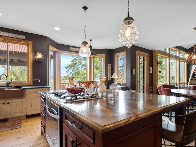 kitchen featuring a center island, sink, light hardwood / wood-style flooring, stainless steel appliances, and a chandelier