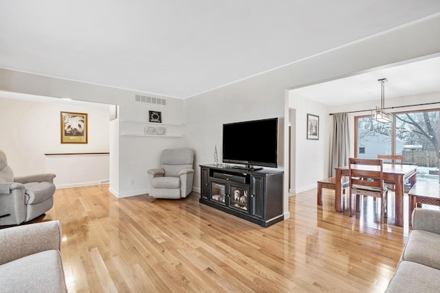 living room with a chandelier and light hardwood / wood-style flooring