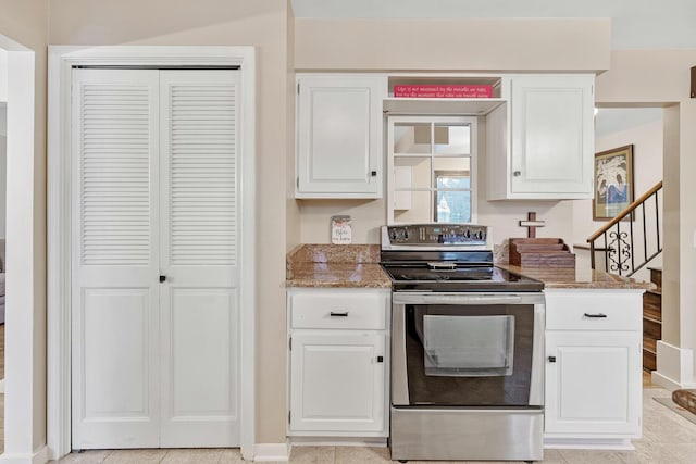 kitchen featuring white cabinetry, electric stove, and light tile patterned floors