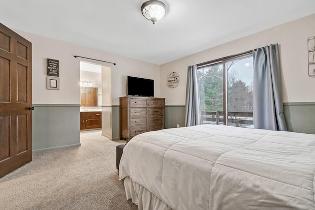 bedroom featuring access to exterior, ensuite bathroom, and light colored carpet