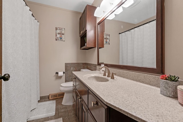 bathroom with tile patterned floors, vanity, toilet, and crown molding