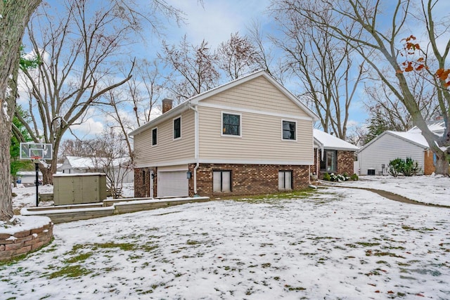 snow covered property with a garage