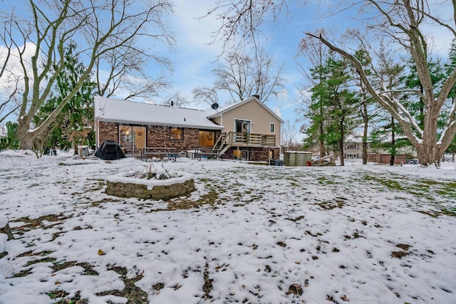 snow covered property featuring an outdoor fire pit