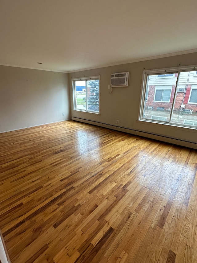 empty room with a baseboard radiator, light hardwood / wood-style floors, and a wall mounted air conditioner