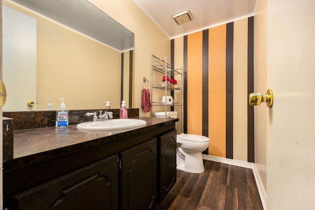 bathroom featuring vanity, wood-type flooring, and toilet