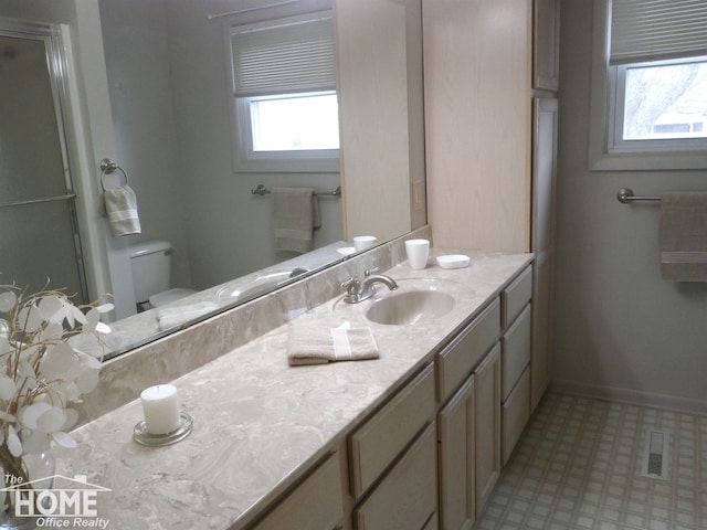 bathroom featuring vanity, toilet, and walk in shower