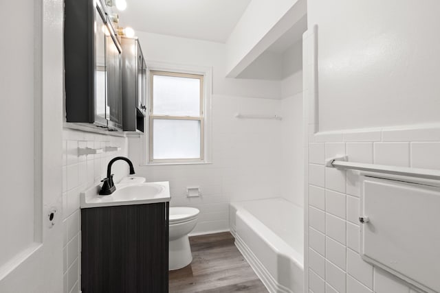 bathroom featuring vanity, toilet, wood-type flooring, and tile walls