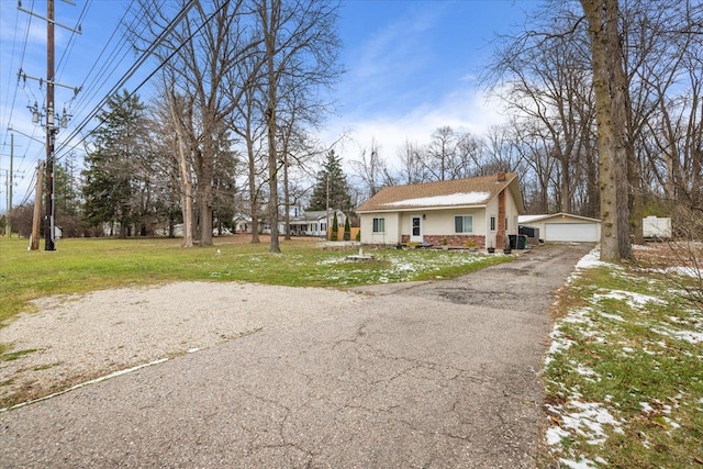 view of front of home with a garage, a front lawn, and an outdoor structure