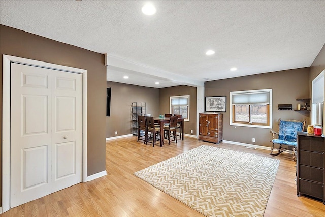 dining room with a textured ceiling and light wood-type flooring