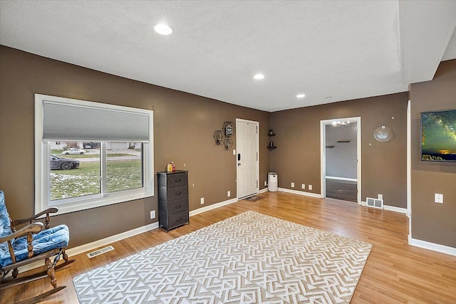 interior space featuring a textured ceiling and light wood-type flooring