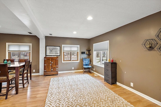 interior space with a textured ceiling and light hardwood / wood-style floors