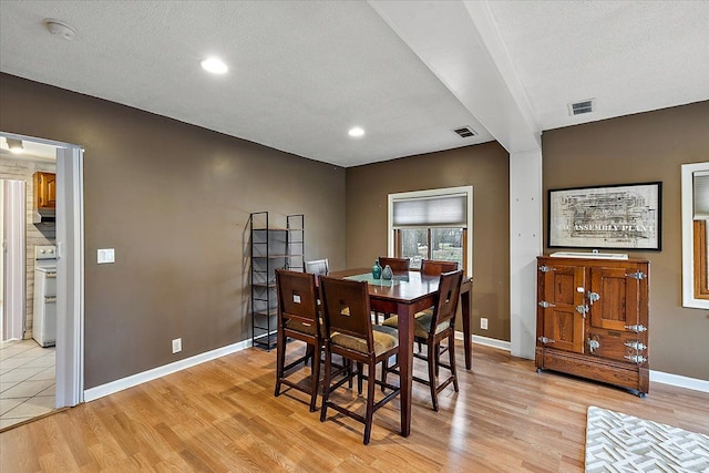 dining area featuring light hardwood / wood-style flooring and a textured ceiling