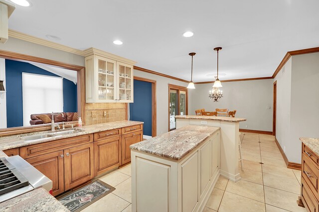 kitchen with sink, hanging light fixtures, light tile patterned floors, decorative backsplash, and a kitchen island