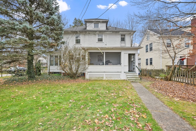 view of front of property with a sunroom and a front yard