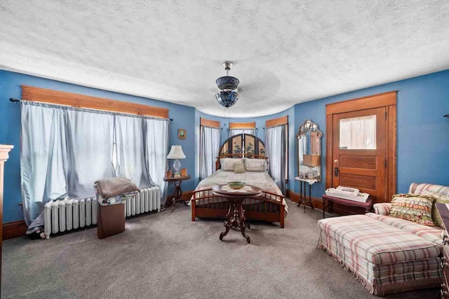 bedroom featuring radiator, a textured ceiling, dark carpet, and ceiling fan