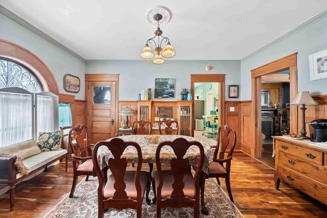 dining space with a notable chandelier, dark hardwood / wood-style flooring, and crown molding