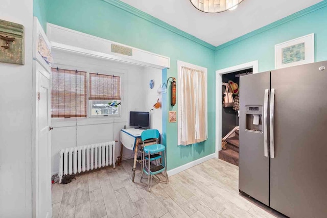 kitchen with crown molding, light wood-type flooring, stainless steel fridge with ice dispenser, and radiator heating unit