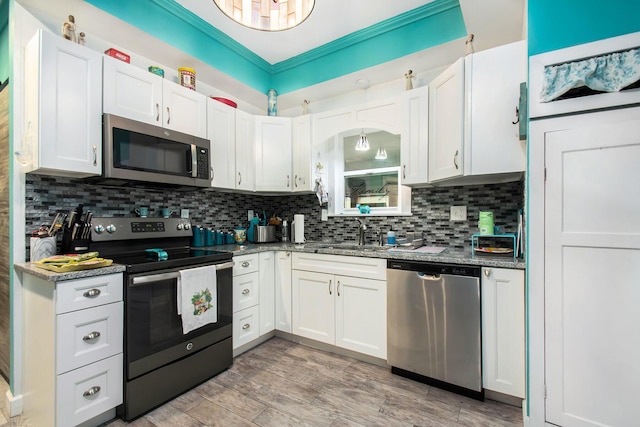 kitchen with white cabinets, appliances with stainless steel finishes, tasteful backsplash, and sink